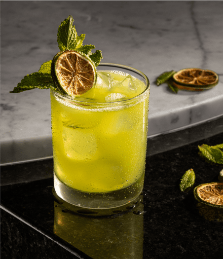 gin cocktail garnished with lime wheel and mint sprig