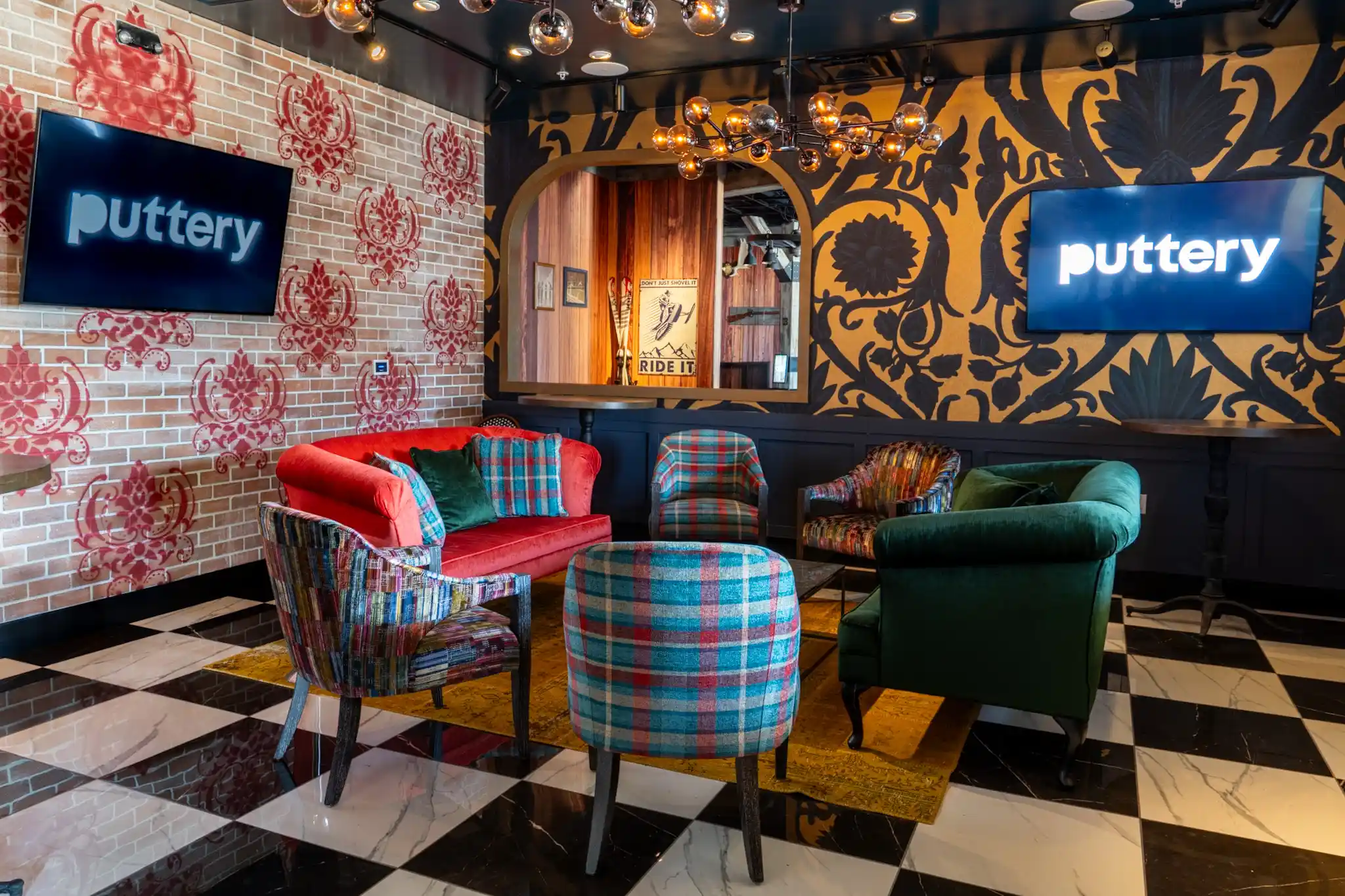 Lounge at Puttery Miami with plaid accent chairs, colorful sofa seating, checkerboard floors and bold patterned walls.