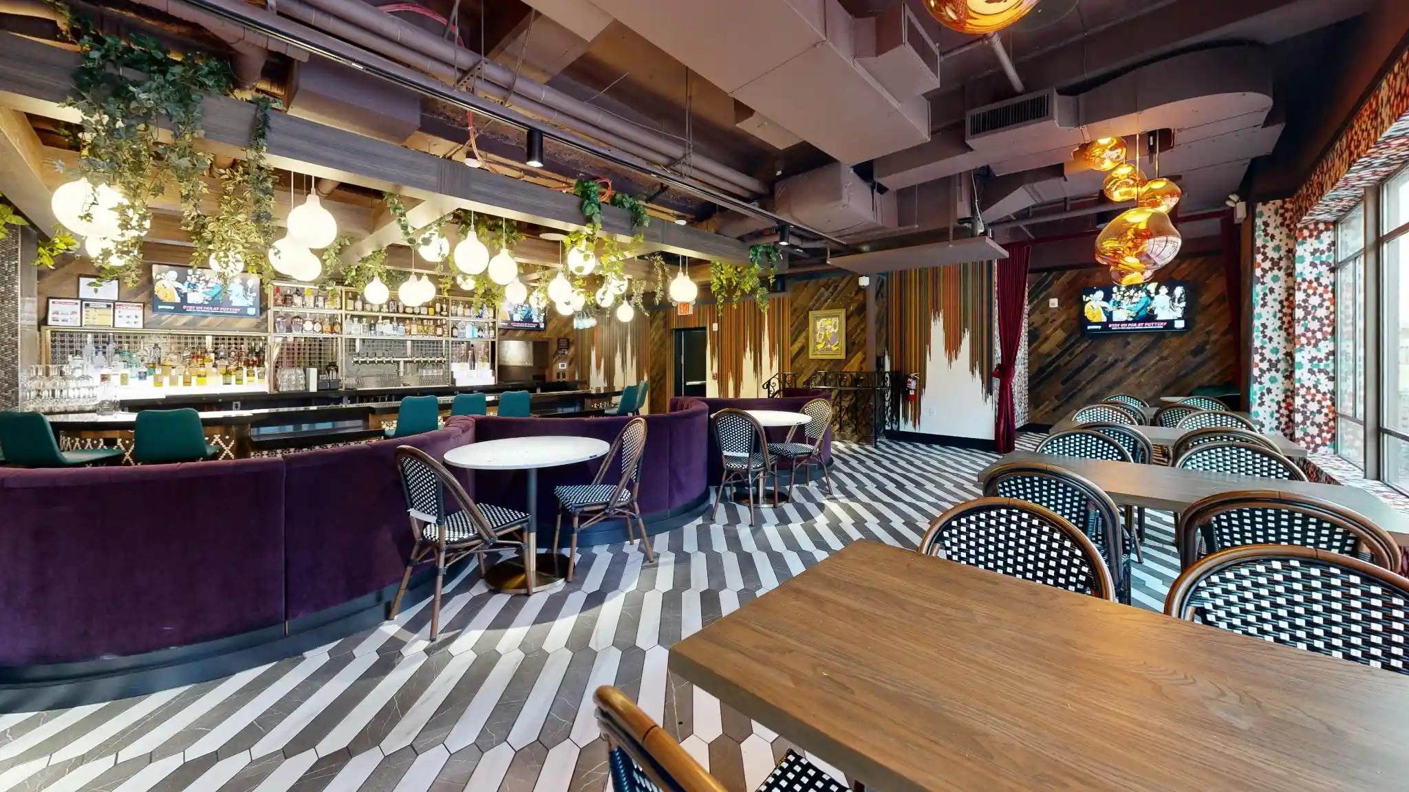 Puttery New York City lounge and dining room with purple banquettes, woven chairs, striped flooring and a full bar.