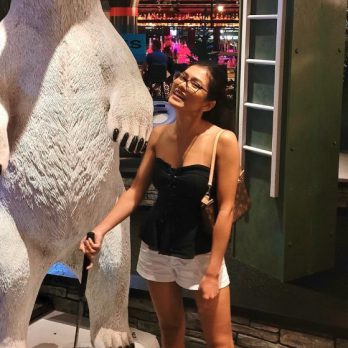 woman standing with putter in front of polar bear statue