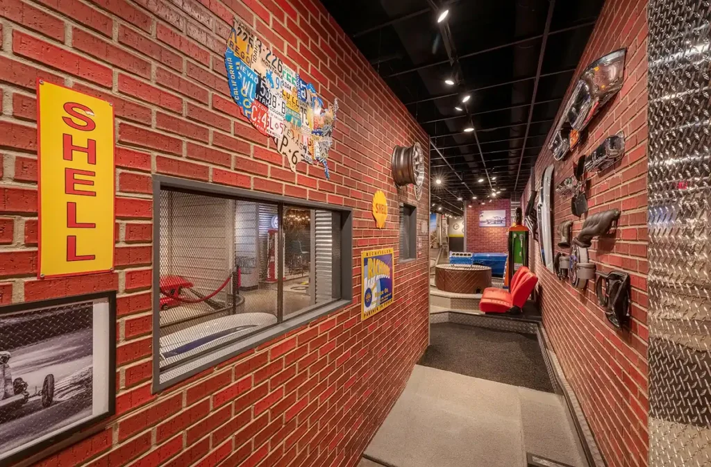 Automotive-themed hallway on the Garage Course at Puttery Pittsburgh with brick walls, vintage signs and industrial details.