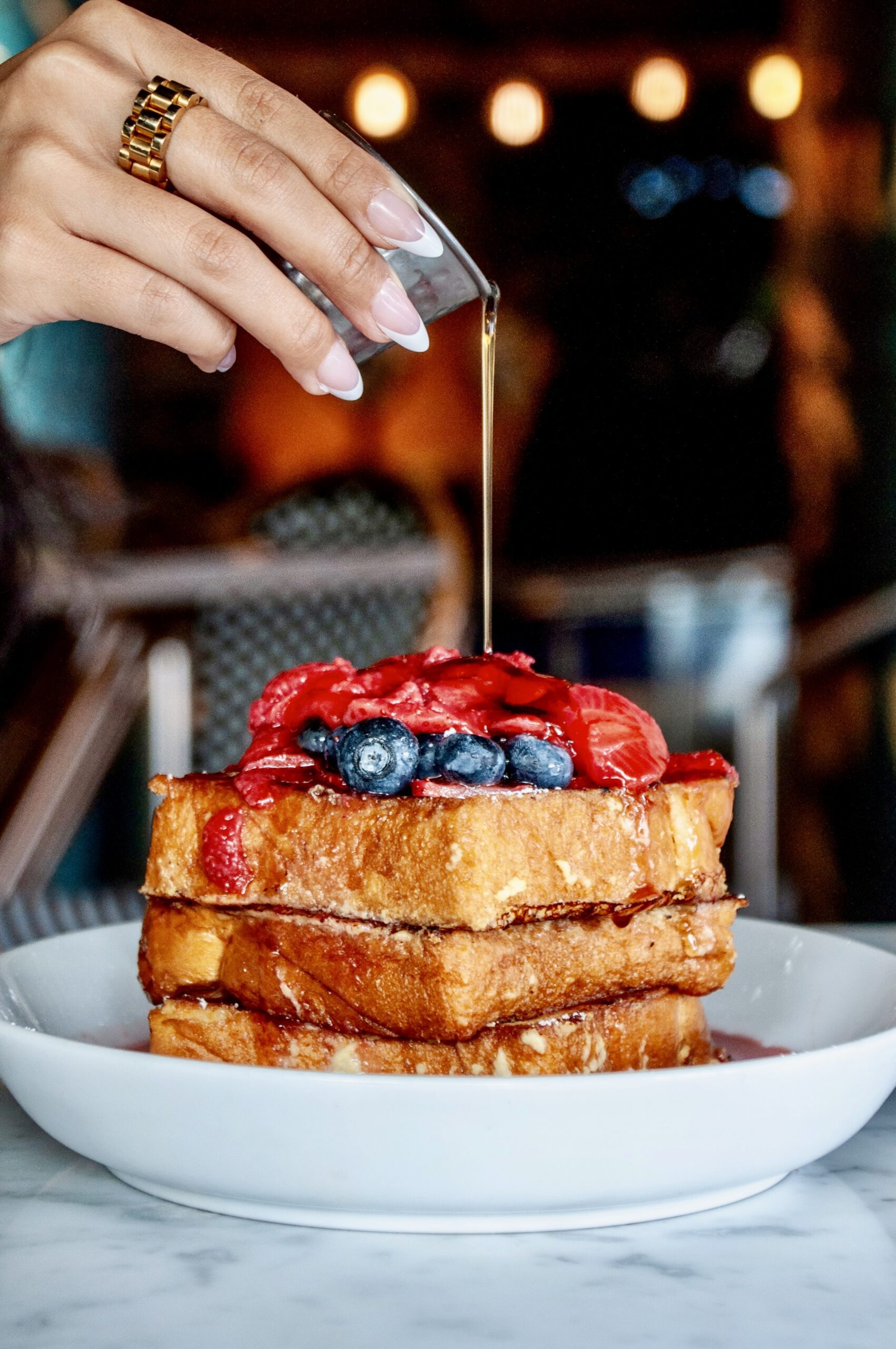 Fluffy French toast with a stream of syrup mid-pour at Puttery.