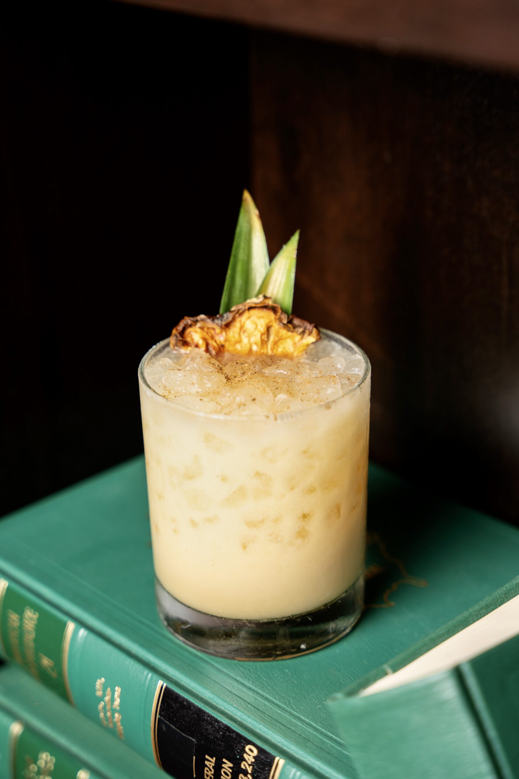 Tranquilizer, Puttery's twist on a painkiller cocktail, displayed on an open book.