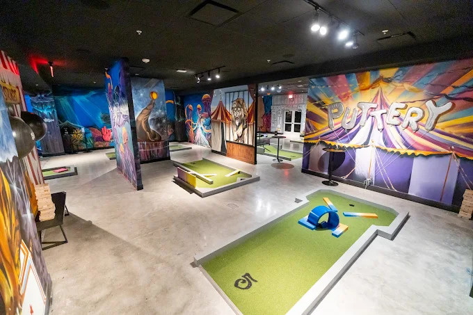 Puttery indoor mini golf inside Drive Shack with colorful course design, putting lanes, and social gameplay.