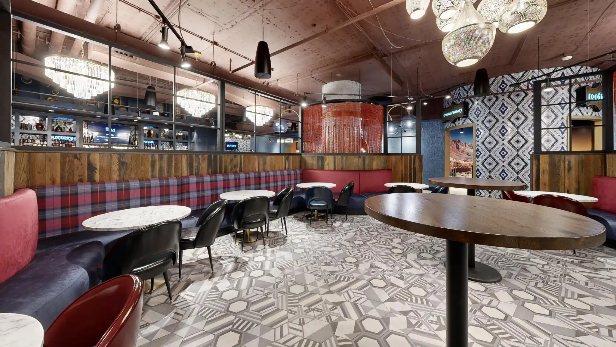 Group dining area at Puttery Kansas City with a plaid banquette, communal table and geometric flooring.