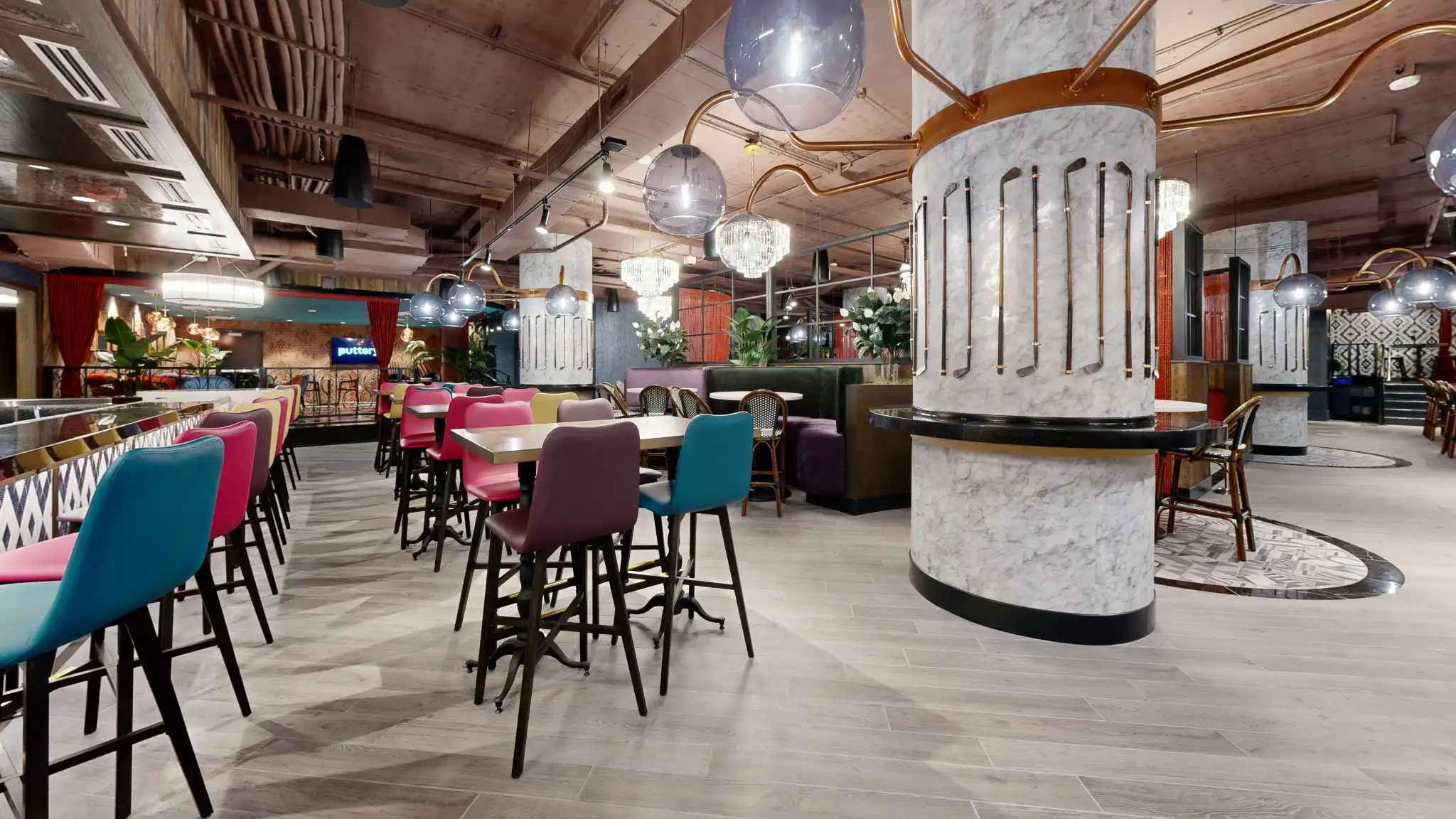 Puttery Kansas City restaurant seating with colorful chairs, high-top tables and putter display columns.