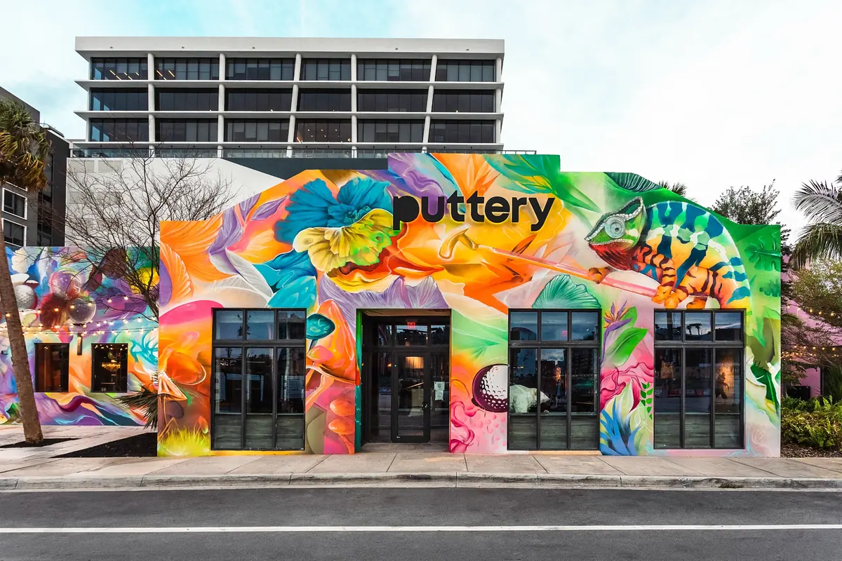 Colorful mural-covered exterior of Puttery Miami in Wynwood, with the Puttery sign above the main entrance.