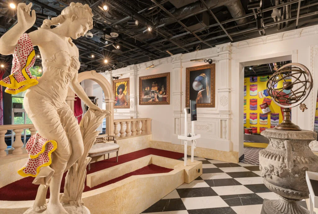 Art museum-themed mini golf course at Puttery featuring classical statues, framed artwork, checkerboard flooring and pop art details.