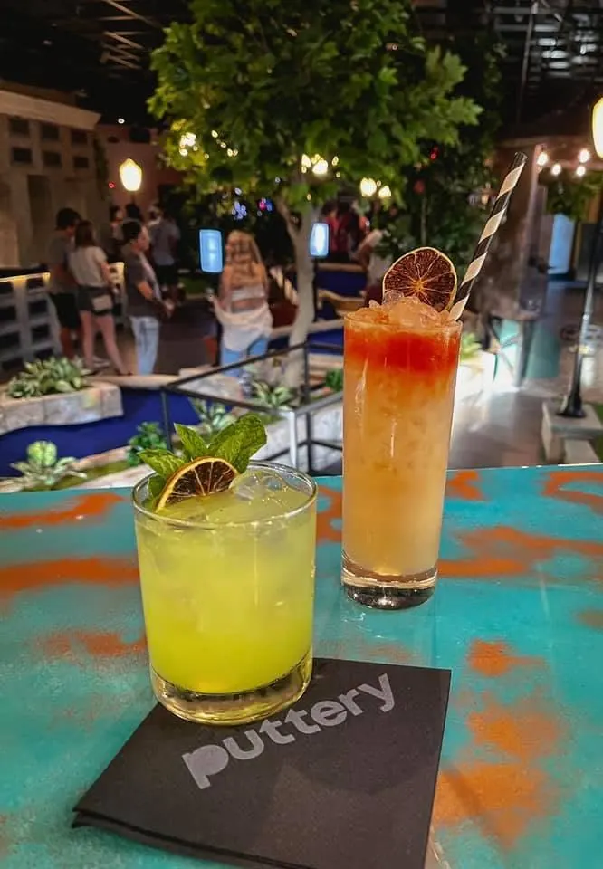 Two craft cocktails overlooking an indoor mini golf course at Puttery Dallas in Grandscape.