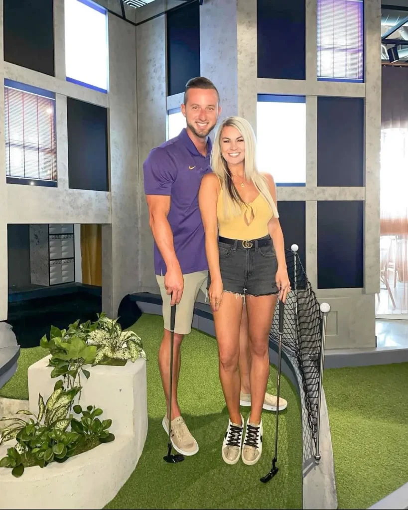 Couple posing with putters on an indoor mini golf course at Puttery Dallas in Grandscape.