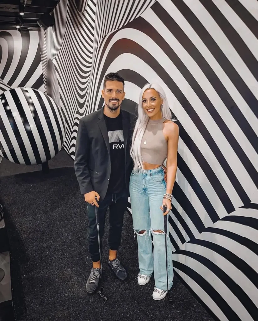 Couple with putters inside the black-and-white Illusion mini golf course at Puttery Dallas.
