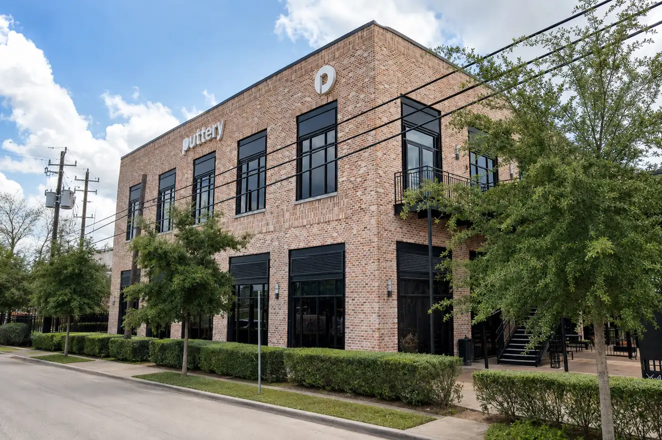 Exterior of Puttery Houston featuring a two-story brick building, black-framed windows and Puttery signage.