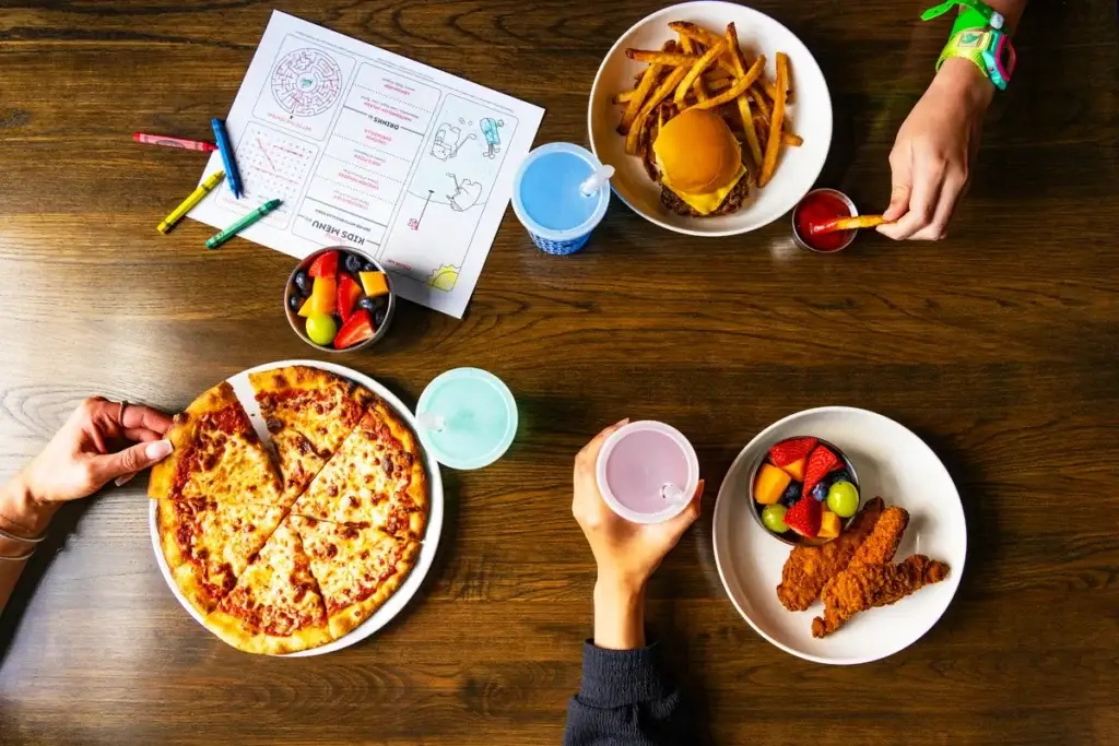 Puttery kids meals with pizza, chicken tenders, a cheeseburger, fruit cups, color changing cups, and a crayon activity menu