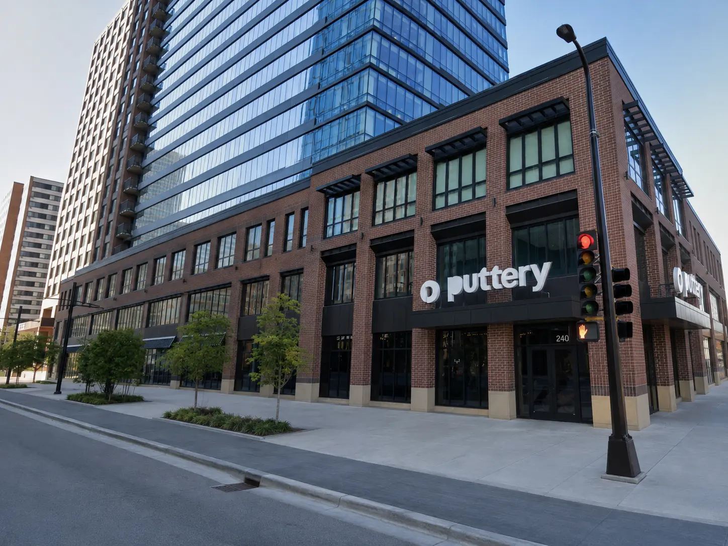 Exterior of Puttery Minneapolis featuring a brick facade, large windows and illuminated Puttery signage.
