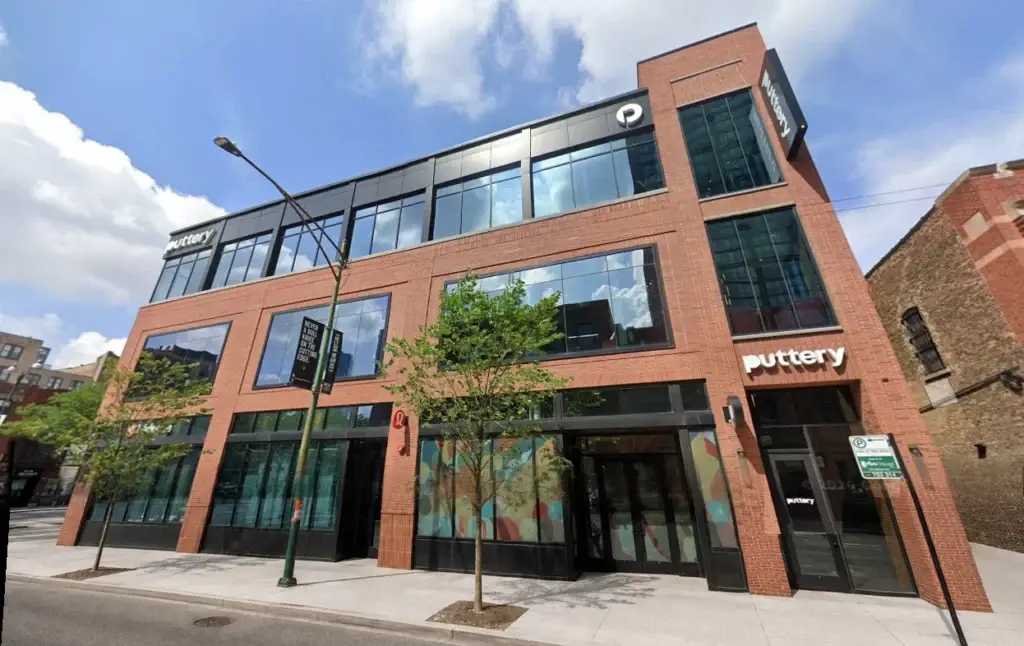 Wide exterior view of Puttery Chicago in Fulton Market with the brick façade, Puttery signage, windows, and entrance.