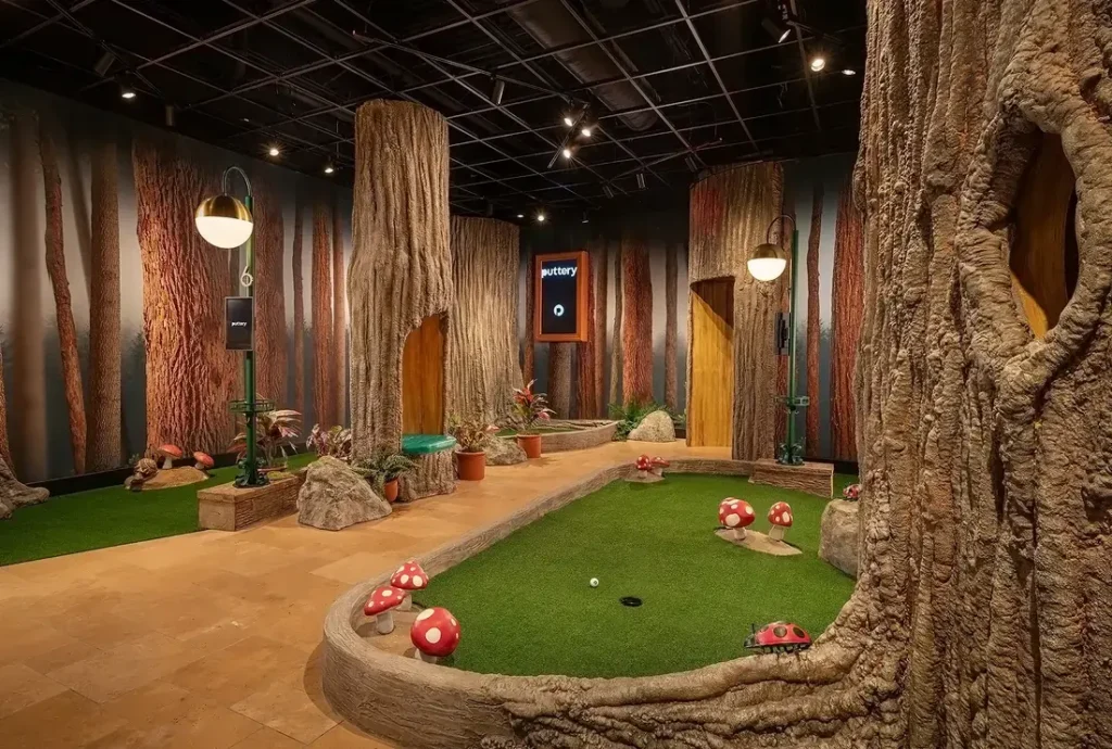 Woodland section of the Conservatory Course at Puttery Charlotte with oversized tree trunks, mushrooms, rocks and forest-inspired putting greens.
