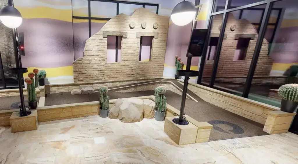 Desert-inspired section of the Conservatory Course at Puttery Houston with cacti, stone ruins and earth-toned putting greens.