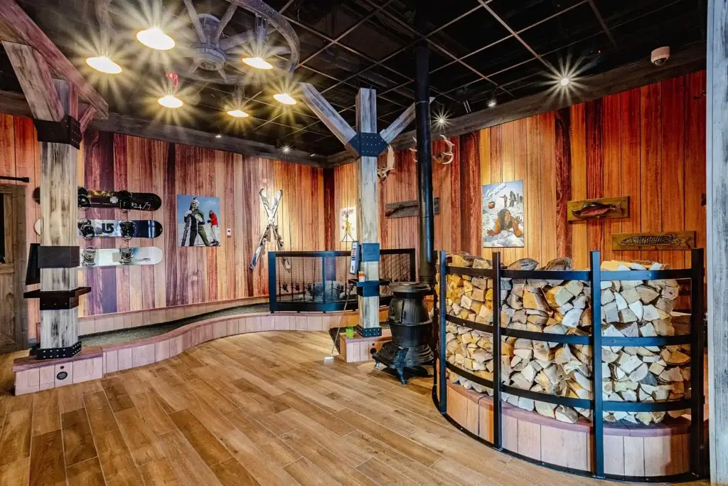 Wide view of the Lodge Course at Puttery Miami with ski and snowboard displays, rustic timber beams, mountain scenery, and winter-themed putting lanes.