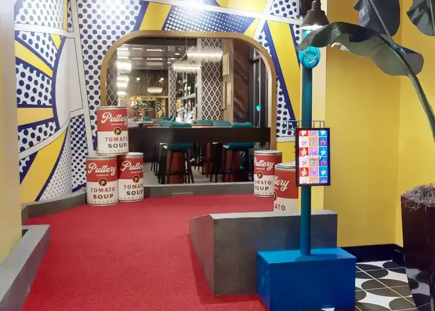 Pop art-inspired mini golf hole with Puttery tomato soup cans and bold comic-style graphics inside the Art Museum course at Puttery Minneapolis.